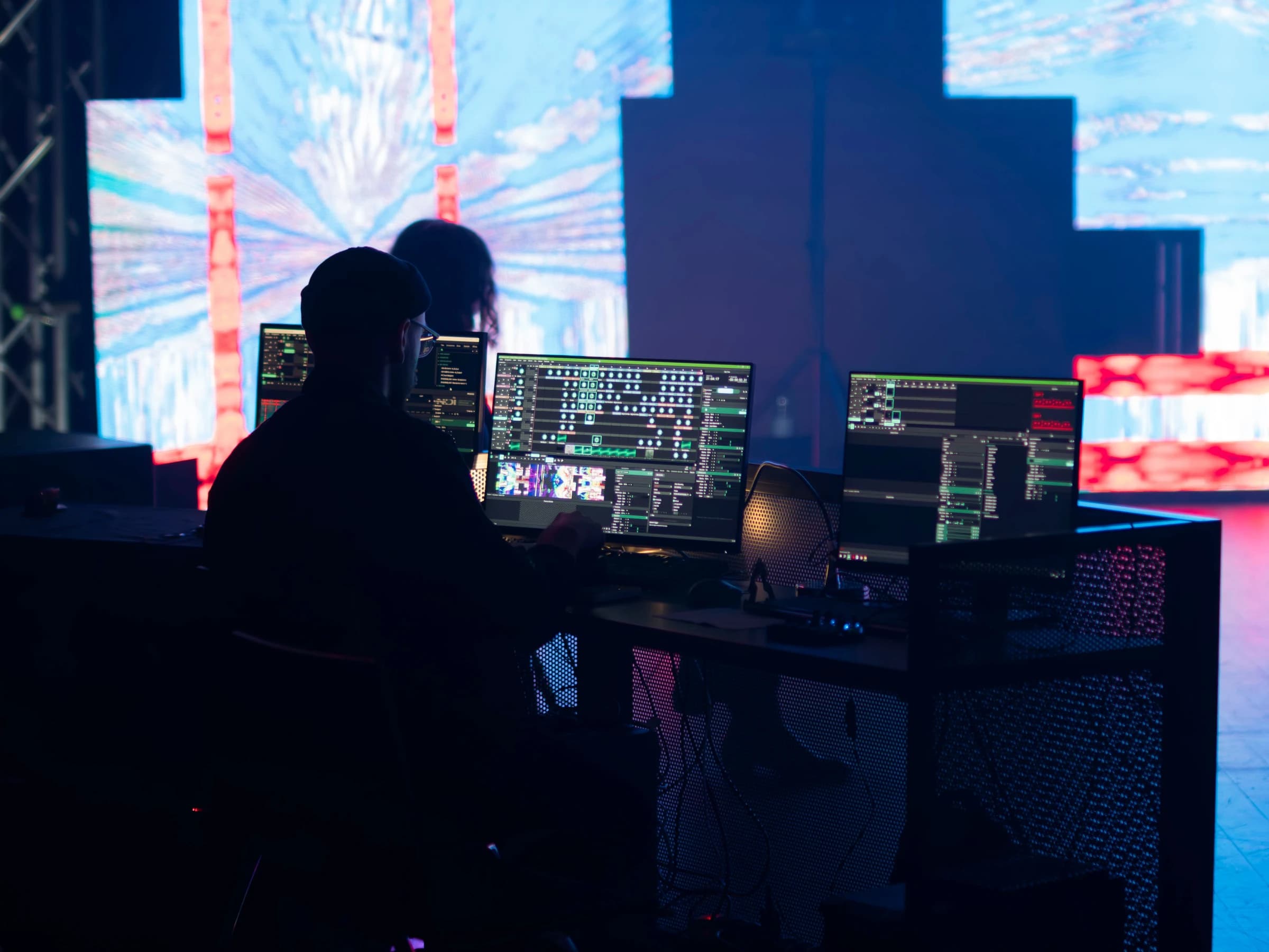Technician at the control desk in front of an LED screen wall during a live event